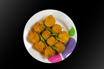 Crispy golden tofu fritters served with green chilies on a colorful plate. Traditional Asian street food snack, deep-fried to perfection with a spicy touch