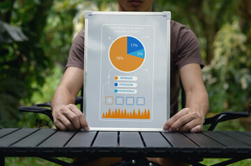 Man Holding Infographic on Sustainability and Technology in Nature