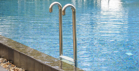Swimming pool with stainless steel ladder stair and blue water