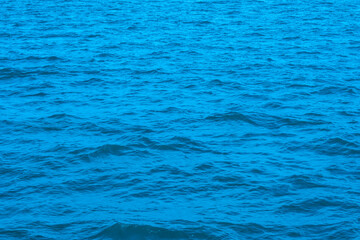 Deep sea waves. The surface of the blue sea has ripples and light reflecting on the sea.
