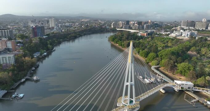 Pull out with slight left panning motion of Kangaroo Point Bridge on the Brisbane River with Brisbane CBD in background, it is a pedestrian bridge only,opened late 2024, Brisbane,Queensland, Australia