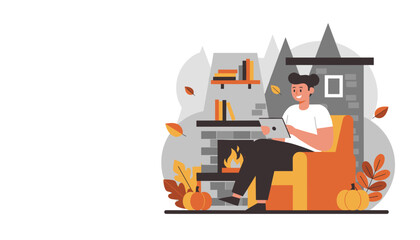 Man enjoying cozy autumn evening relaxing by the fireplace while using a tablet