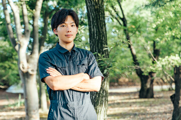 作業着を着た男性が腕を組む