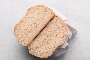 Overhead view of sliced homemade artisan bread on marble countertop, top view of cross-section of sourdough artisan bread