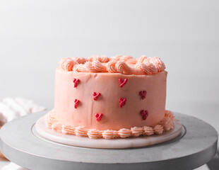 Peach buttercream cake on a cake plate, valentines Cake covered in red buttercream hearts