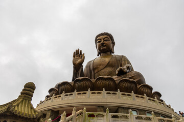 Obraz premium Giant tian tan buddha statue sitting on mountain peak in hong kong