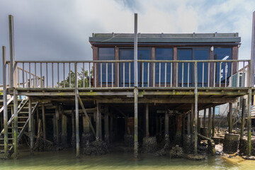 Fishing boats on waterway and floating stilt house at Tai O, a traditional Chinese Fishing Village known as Venice of the Orient, in Hong Kong
