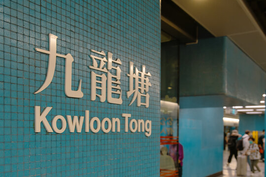 Kowloon tong mtr station sign with blurred people walking by