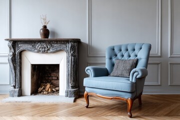 A blue tufted armchair sits next to a stone fireplace with logs inside.