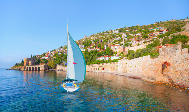 Landscape of ancient shipyard near of Kizil Kule tower with lone yacht - Alanya peninsula, Turkey