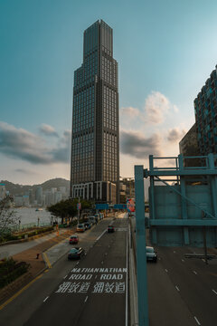 Traffic flowing on nathan road with modern skyscraper towering above in hong kong