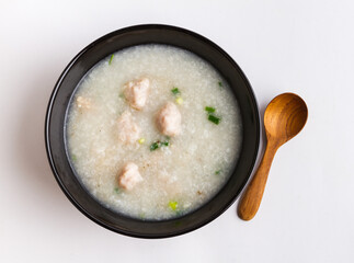 Traditional Asian Rice Porridge with Pork Meatballs. Pork Congee (Jok) in Black Bowl, Top View