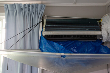 Air conditioning technician cleaning air conditioner unit