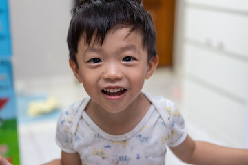 Happy asian toddler boy smiling and playing at home