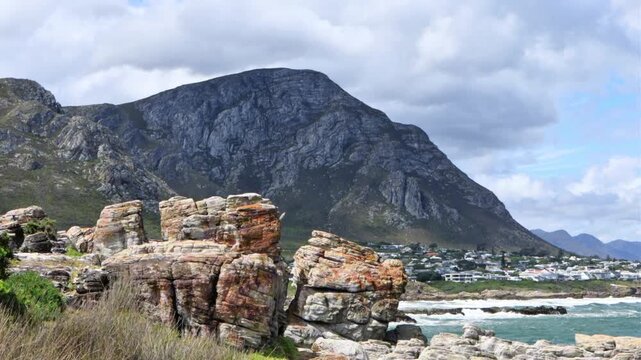 4K footage of the the klein river mountain in hermanus next to the sea with diverse rock formations in the foreground during the day in South Africa 
