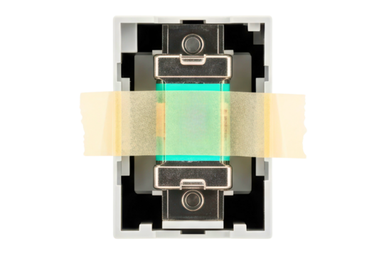 Automotive blade fuse held in a holder with masking tape on a transparent background