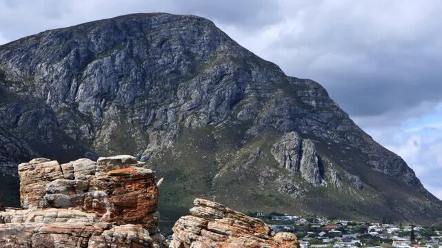 4K footage of the the klein river mountain in hermanus next to the sea with diverse rock formations in the foreground during the day in South Africa 
