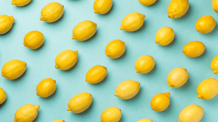 Fresh yellow lemons arranged neatly on a bright blue background showcasing their vibrant color and texture pattern