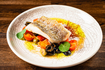 A lovely dish showcases grilled fish, vibrant vegetables, and saffron, delighting the senses