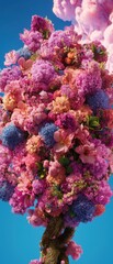 Obraz premium Vibrant Floral Tree with Colorful Blossoms Against Blue Background