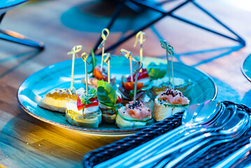 A vibrant platter filled with various tasty appetizers awaits guests at a sunny outdoor event