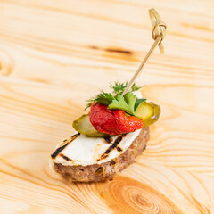 Delicious appetizer features grilled meat topped with vegetables and herbs, perfect for sharing