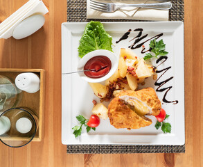 A colorful plate features crispy chicken, seasoned potatoes, and fresh lettuce for a tasty meal