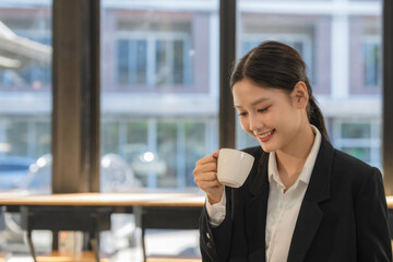 Coffee break at work, Asian businesswoman drinking coffee at the office.