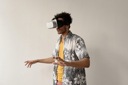 Young male student playing games using virtual reality headset