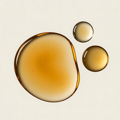 Closeup of amber liquid droplets on a light background