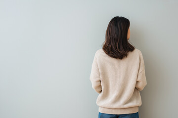 壁に向かって立つ女性の後ろ姿と孤独のコンセプト