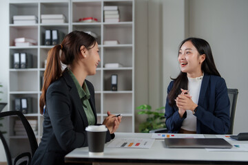 Businesswomen discussing project details in office setting