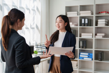 Businesswomen discussing project details during an office meeting