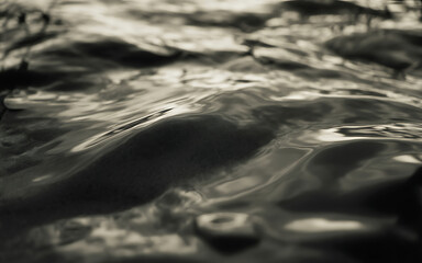 Closeup abstract view of rippling water surface with dramatic lighting and shadows