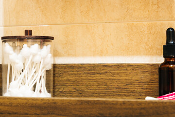Cotton swabs inside jars on a wooden shelf