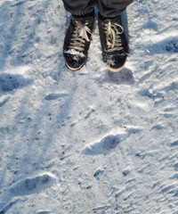 Black men's winter boots in the snow, top view.