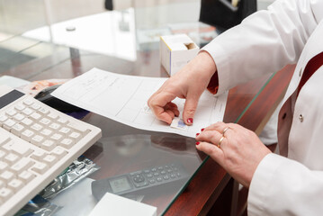 Close up of Pharmacist attaching medicine barcode to prescription in pharmacy