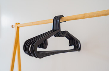Black plastic hangers hang on a clothesline.