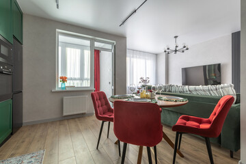 Modern Living Room and Kitchen with Red Chairs and Green Sofa