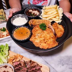 A Delicious Fried Pork Cutlet Meal with Fries and Sauces