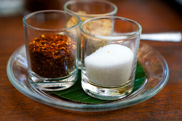Chili Flakes and Sugar in Clear Glasses – Side Angle