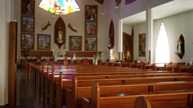 Wooden pews in soft shallow focus with blurred altar and stained glass bokeh church; background backplate copyspace calm.