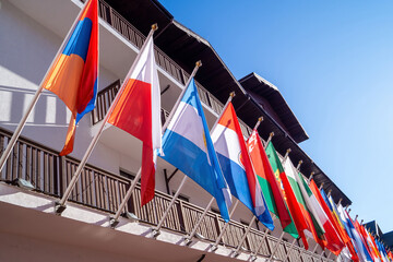 Colorful flags display on a building in a sunny location with clear blue sky