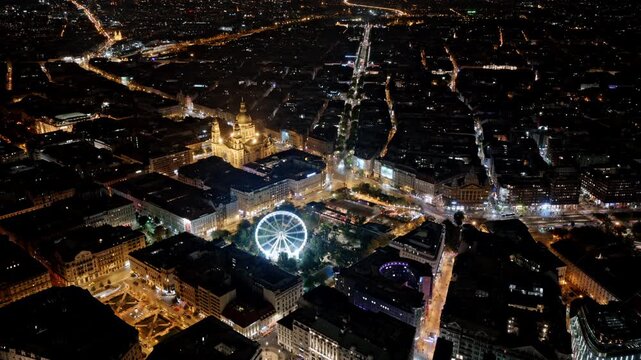 Budapest&rsquo;s downtown sparkles at night with St. Stephen&rsquo;s Basilica and the Budapest Eye radiating bright energy in the heart of the city.