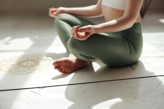 Female practicing padmasana in lotus position at home