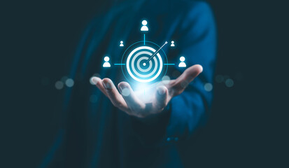 Businessman holding digital target icon with customer network, symbolizing marketing strategy, audience targeting, customer relationship management, and digital business success concept.