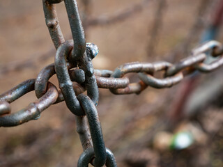Close up of old rusty metal chain links with corrosion and weathered surface texture showing age and deterioration