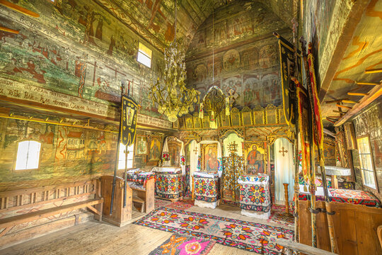 Maramures, Romania - Aug 14, 2025: Saint Parascheva Church interior in Poienile Izei, Maramures in Romania. ornate wooden Romanian Orthodox space with vivid frescoes, icons, carved iconostasis