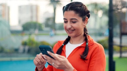 Phone, fitness and woman on tennis court for networking, communication or social media on mobile app. Happy, sports and female person typing on cellphone for texting, contact or chatting outdoor. - Powered by Adobe