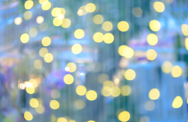 Soft focused festive abstract background of yellow bokeh lights scattered on dreamy pastel blue